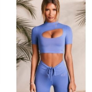 Purple cut out sports top. Can be dressed up with jeans. Pants not included